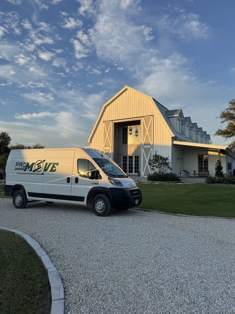 PRO MOVE's branded delivery van at a Texas ranch home at golden hour
