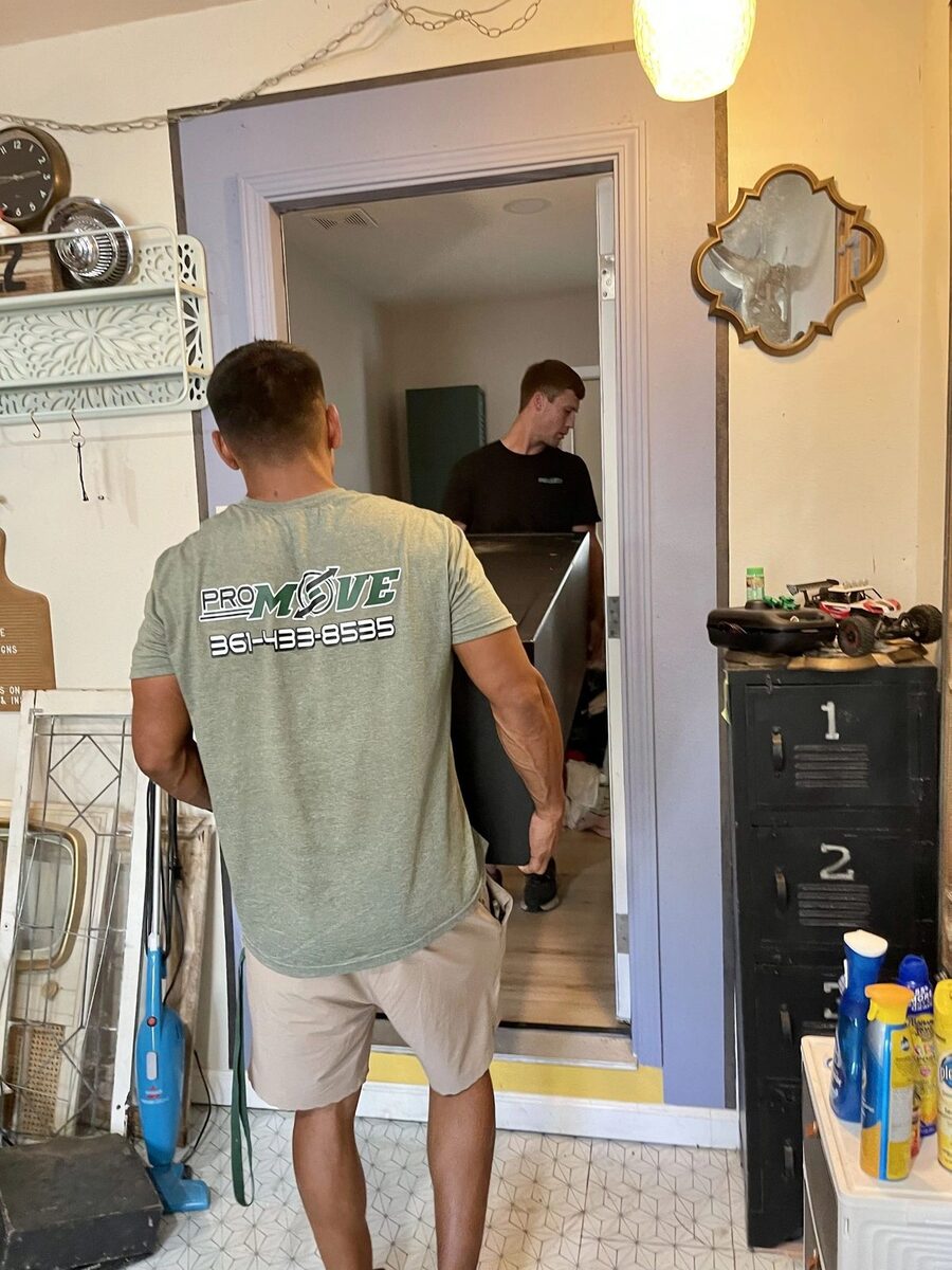PRO MOVE crew carefully carrying a heavy piece through a home on a residential move