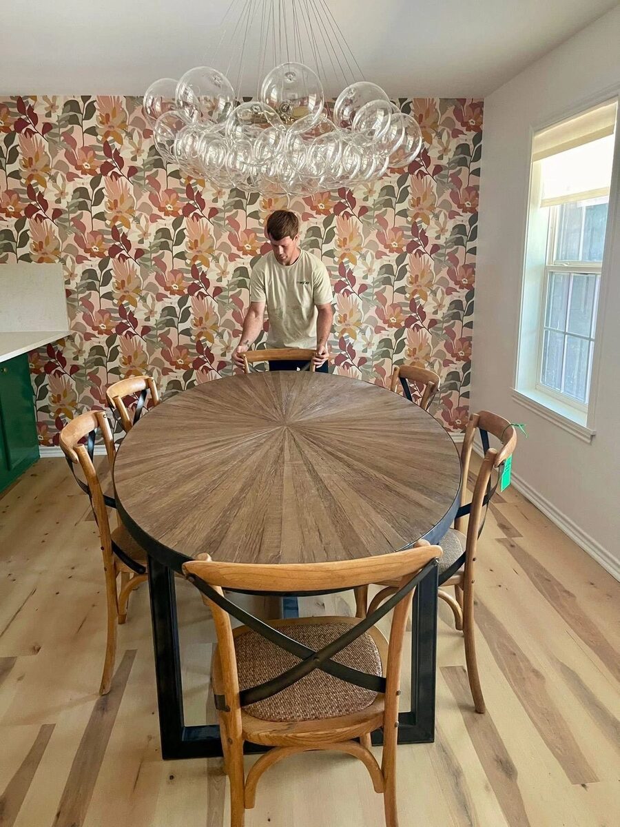 PRO MOVE crew placing an antique dining table and chairs in a styled client's room